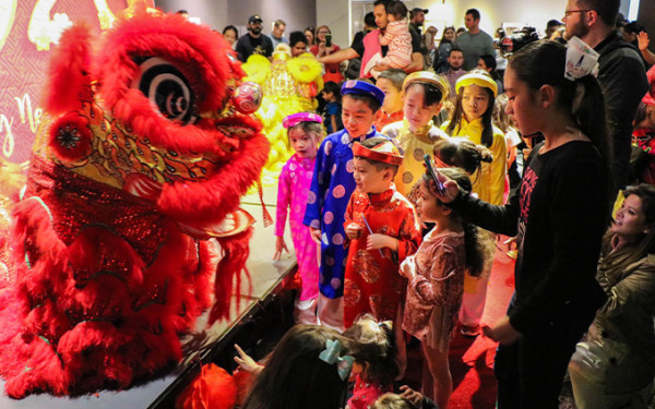 Dragon dance and kids in chinese dress watching